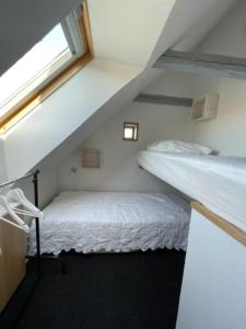 a bedroom with two bunk beds and a window at Skønt feriehus midt i Marstal. in Marstal