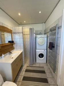 uma casa de banho com uma máquina de lavar roupa e um lavatório em Skønt feriehus midt i Marstal. em Marstal