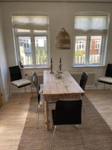 a dining room with a wooden table and chairs at Skønt feriehus midt i Marstal. in Marstal