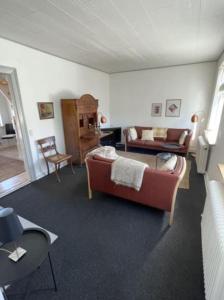 uma sala de estar com um sofá e uma cadeira em Skønt feriehus midt i Marstal. em Marstal