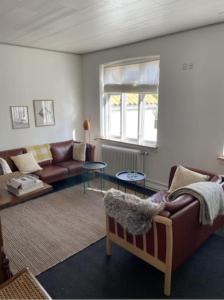 a living room with a couch and a table at Skønt feriehus midt i Marstal. in Marstal