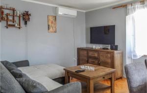 ein Wohnzimmer mit einem Sofa und einem Tisch in der Unterkunft Awesome Apartment In Unije With Wifi in Unije