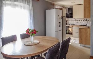 a kitchen with a table with a vase of flowers on it at Awesome Apartment In Unije With Wifi in Unije