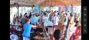 a crowd of people standing around a bar at Green Mango Bungalows in Kampot