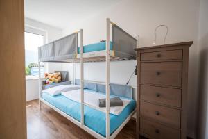 a bedroom with two bunk beds and a dresser at MOOKI Lake Apartment Ossiacher See&Gerlitzen in Sattendorf