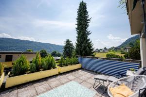 a patio with a table and chairs and a tree at MOOKI Lake Apartment Ossiacher See&Gerlitzen in Sattendorf