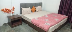 un piccolo letto con una coperta rossa e un tavolo di The Green Garden Retreat, Dooars a Sukhani