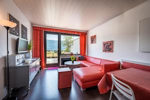 a living room with a red couch and a tv at Wohnung Seeblick in Sattendorf