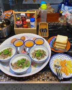 una mesa con platos y tazones de comida. en ภูคำฮ้อมคลิฟฟ์ลอดจ์ แอนด์ โฮมสเตย์ Phu come home cliff Lodge & Homestay, en Ban Phu Hi