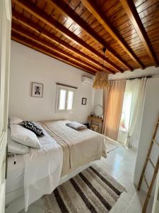 a bedroom with a bed and a wooden ceiling at Lux Mykonos house in Agios Stefanos