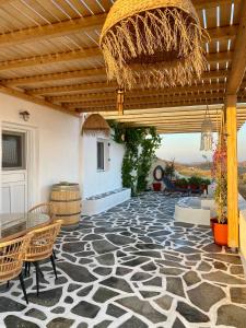 a patio with a stone floor with a wooden ceiling at Lux Mykonos house in Agios Stefanos