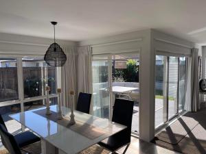 a dining room with a glass table and chairs at Lakes Executive Suites in Tauranga