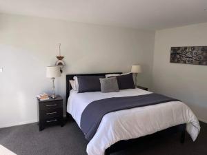 a bedroom with a large bed and two lamps at Lakes Executive Suites in Tauranga