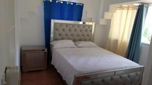 a bedroom with a bed with a blue curtain at tropicana sur apt221 in Sosúa