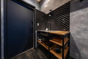 a bathroom with a sink and a black wall at Inn The Omotesando in Tokyo
