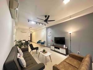 LM HomeyB 3BR Coastline Family Suite for 4-14 Pax with Nexflix & Coway Water Purifier في Tanjong Tokong: غرفة معيشة مع أريكة وتلفزيون بشاشة مسطحة