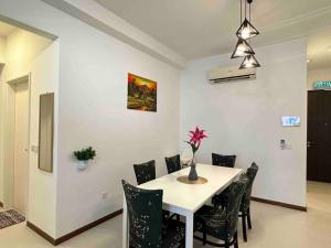 uma sala de jantar com uma mesa branca e cadeiras em LM HomeyB 3BR Coastline Family Suite for 4-14 Pax with Nexflix & Coway Water Purifier em Tanjong Tokong