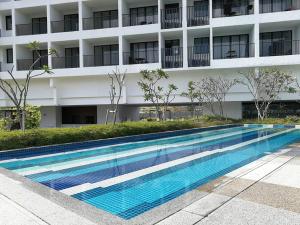 Tanjong Tokong的住宿－LM HomeyB 3BR Coastline Family Suite for 4-14 Pax with Nexflix & Coway Water Purifier，大楼前的游泳池
