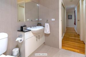 a bathroom with a sink and a toilet and a hallway at StayCentral - Tranquil Spacious Townhouse in Melbourne +39 photos
