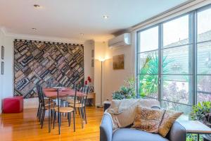 a living room with a couch and a table and chairs at StayCentral - Tranquil Spacious Townhouse in Melbourne