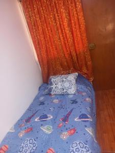 利馬的住宿－GEDEON apartament airport，一张带蓝色棉被和橙色窗帘的床