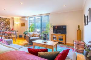 a living room with a couch and a tv at StayCentral - Tranquil Spacious Townhouse in Melbourne