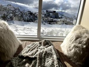 a window with a view of a snow covered mountain at Chalet 3 in Mount Hotham