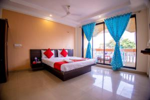 a bedroom with a bed and a large window at Hotel Om Palace in Lonavala