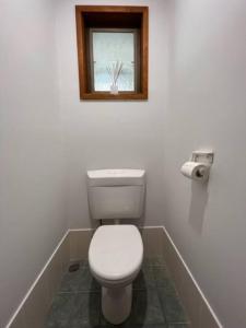 a bathroom with a white toilet and a window at Waterfront Bliss in Port Macquarie