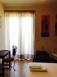a bedroom with a bed and a desk and a window at Zahir da Cleo in Castro di Lecce