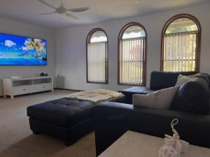 a living room with a couch and a tv at Waterfront Bliss in Port Macquarie