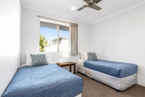 una camera da letto con due letti e una finestra di 7 Pelican Beach Resort a Noosaville