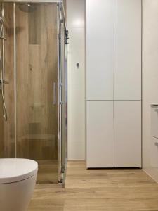 a bathroom with a toilet and a glass shower at Apartament nr 35 - Apartamenty Wakacyjna 5 in Mielno