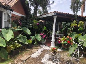 un jardín con 2 bicicletas estacionadas bajo una pérgola en Linda cabaña con el mejor clima en Rionegro