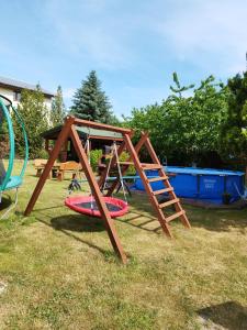 a playground with a swing and a slide at Szyper pokoje i domki in Władysławowo