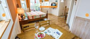 a table and chairs in a room with a bedroom at Didimdol Pension in Geoje