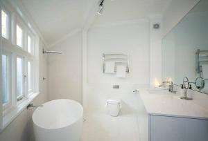 La salle de bains blanche est pourvue de toilettes et d'un lavabo. dans l'établissement Private Rooftop Penthouse in the Heart of Sydney, à Sydney