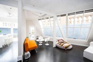 Cette chambre blanche dispose d'un lit, de chaises et de fenêtres. dans l'établissement Private Rooftop Penthouse in the Heart of Sydney, à Sydney