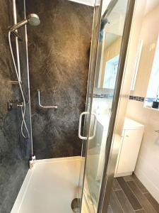 een douche met een glazen deur in de badkamer bij Cheerful 2 Bedroom Home with Off-road parking in Deysbrook