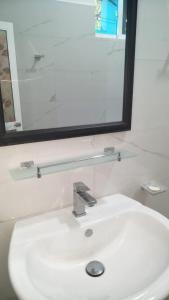 y baño con lavabo, espejo y espejo. en Sandaru Hotel & Homestay, en Katugastota