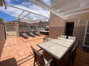 un patio con una mesa blanca y sillas en Apartment With Jacuzzi and pool access, en Puerto Rico de Gran Canaria