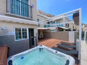 uma banheira de hidromassagem no pátio de uma casa em Apartment With Jacuzzi and pool access em Porto Rico