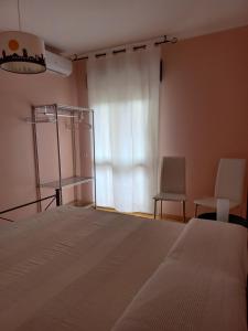 a bedroom with a bed and two chairs and a window at A un passo da... B&B in Elmas