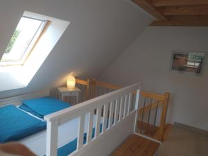 um quarto no sótão com uma cama e uma janela em Ferienwohnung Brox em Sebnitz