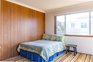 1 dormitorio con cama y ventana en Berrara Cove Beach House en Berrara