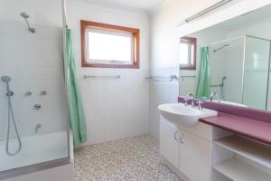 a bathroom with a sink and a shower at Berrara Cove Beach House in Berrara