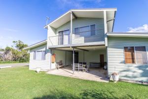 una casa con patio y patio en Berrara Cove Beach House, en Berrara