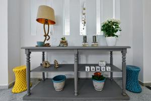 a table with a lamp and plants on it at Kalidon beach Hotel in Kokkari