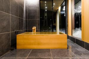 a bathroom with a wooden tub in a room at Hakuba Jolie Maison by Jade Villa in Hakuba
