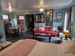 ein Wohnzimmer mit einem roten Sofa und einem Tisch in der Unterkunft ART DECO 1930s Design in Napier